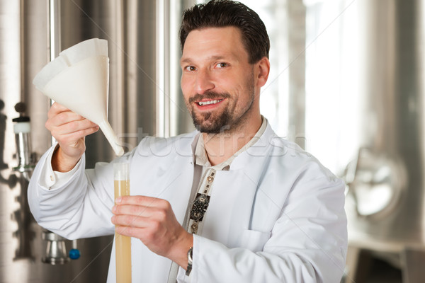 Beer brewer in his brewery examining Stock photo © Kzenon