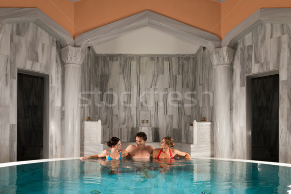 Three friends in swimming pool or thermal bath Stock photo © Kzenon