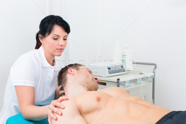 Physiotherapist set patient in practice   Stock photo © Kzenon
