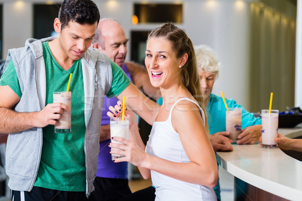 People drinking protein shakes in fitness gym Stock photo © Kzenon