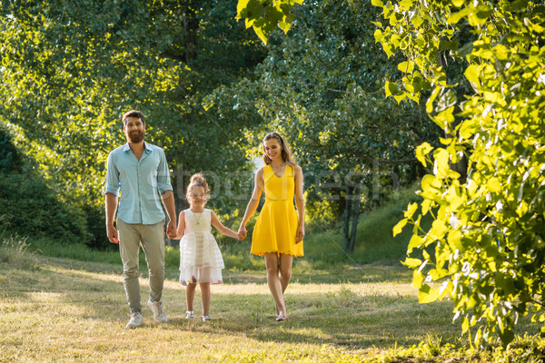 Caring parents holding hands of daughter while walking together  Stock photo © Kzenon