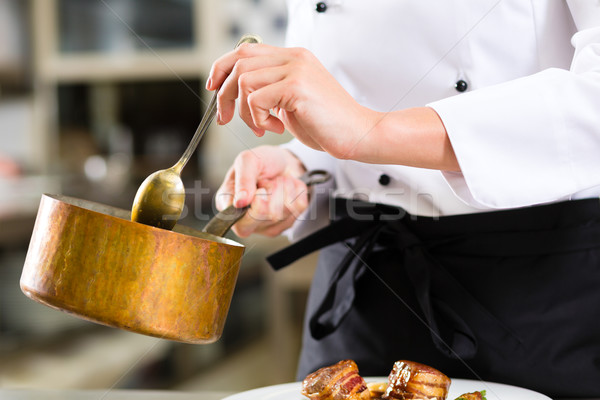 Stock photo: Female Chef in restaurant kitchen cooking