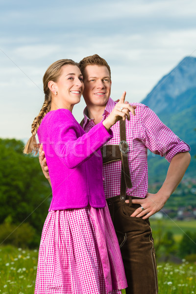 Happy couple in Alpine meadow in Tracht Stock photo © Kzenon