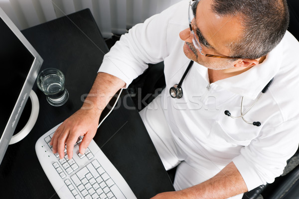 Doctor working at the PC Stock photo © Kzenon