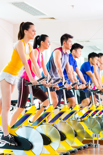 Asian people in spinning bike training at fitness gym Stock photo © Kzenon