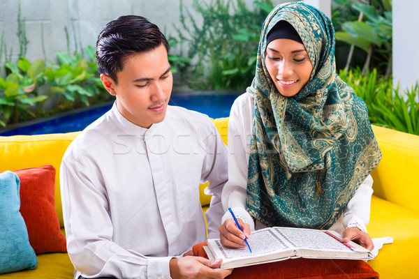 Asian Muslim couple reading together Koran or Quran  Stock photo © Kzenon