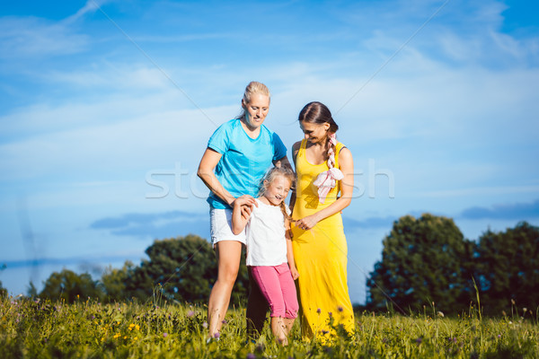 Two women with child on a meadow Stock photo © Kzenon