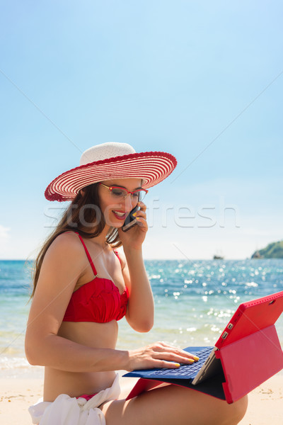 Fashionable young woman talking on mobile phone at the beach Stock photo © Kzenon