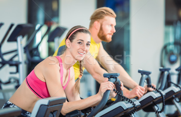 Portrait of a beautiful woman during cardio routine on stationary bicycle Stock photo © Kzenon