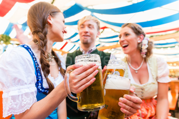 Friends with beer glasses at Bavarian beer tent Stock photo © Kzenon