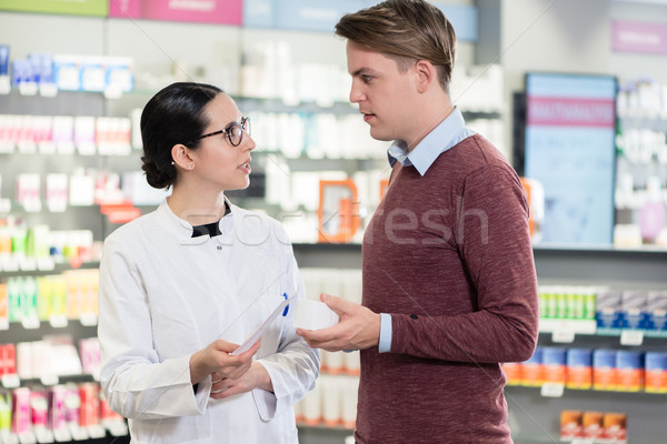 Young man reading the prescription of an important medicine next to a pharmacist Stock photo © Kzenon