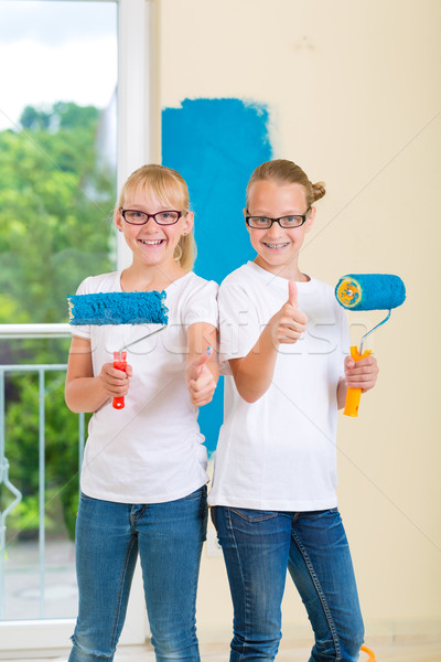Girls painting a wall in the family home Stock photo © Kzenon