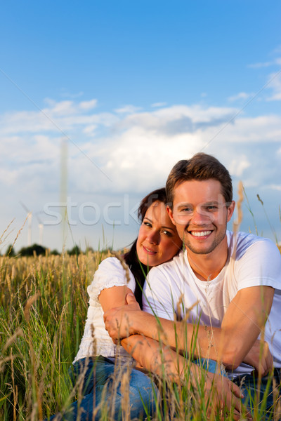 Stock photo: Happy couple sitting on a meadow or grainfield
