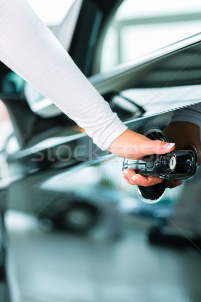 Young woman and seller with auto in car dealership Stock photo © Kzenon