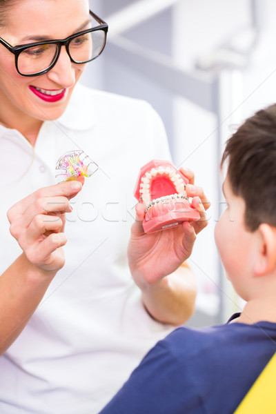 Stock photo: Female Orthodontist explaining boy braces 
