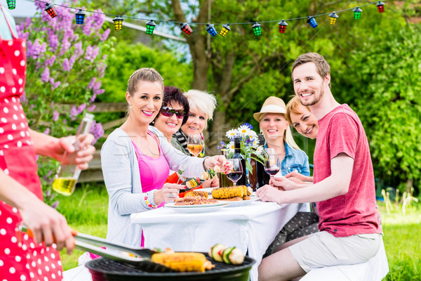 Stock photo: Man grilling meat and vegetables on garden party