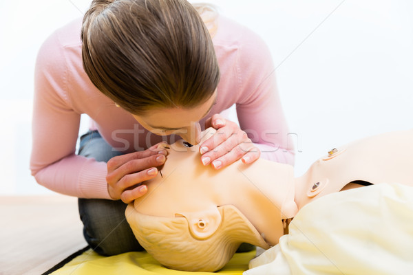 Woman training mouth-to-mouth breath donation on dummy Stock photo © Kzenon