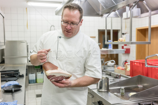 Satisfied chef inspecting delicious smoked ham in a piece  Stock photo © Kzenon