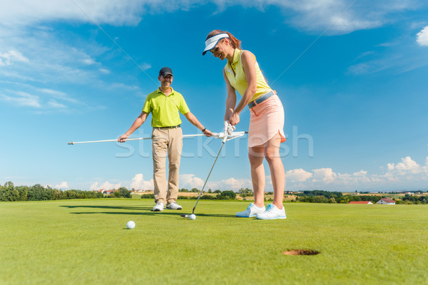Full length of a woman playing professional golf with her male m Stock photo © Kzenon