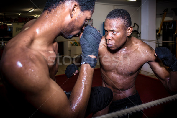Stock photo: Determined offensive fighter hitting his opponent while practici