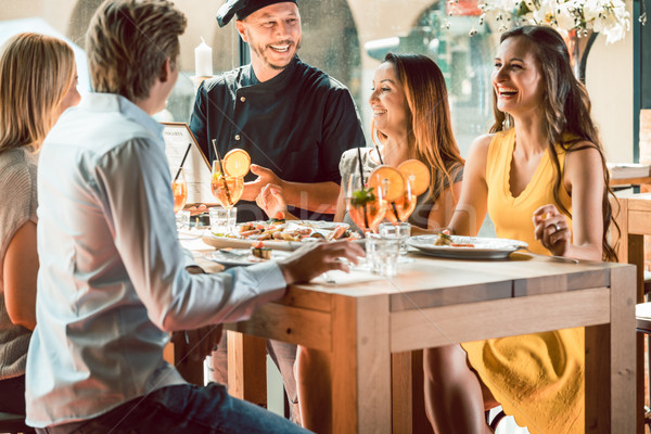 Experienced chef congratulated by four people at a trendy restaurant Stock photo © Kzenon
