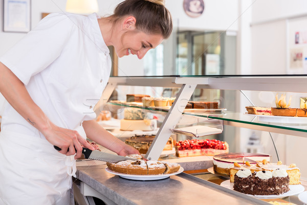 Baker sales woman putting pies and cakes on display Stock photo © Kzenon