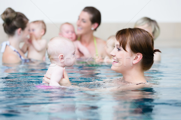 Group of mothers with children at baby swimming lesson Stock photo © Kzenon