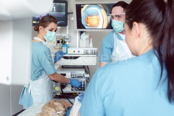 Team of doctors in hospital at endoscopy examining pictures Stock photo © Kzenon