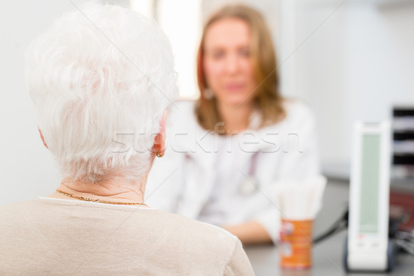 Doctor seeing senior patient in practice Stock photo © Kzenon