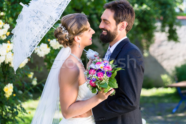 Bridal couple embracing each other in summer garden Stock photo © Kzenon