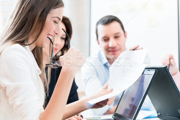 Women and men in office reading documents Stock photo © Kzenon