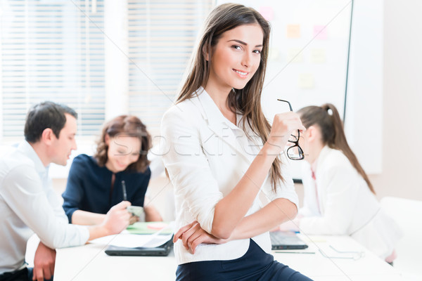 Woman working in office and group having business meeting Stock photo © Kzenon