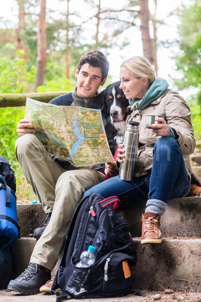 Man and woman on hike planning next route section on map Stock photo © Kzenon