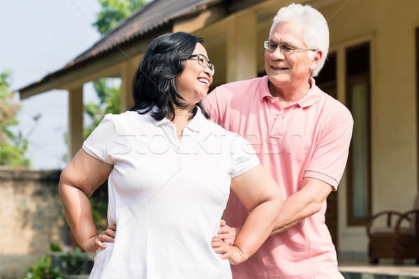 Stock photo: Senior man assisting his wife during warming up exercises outdoo