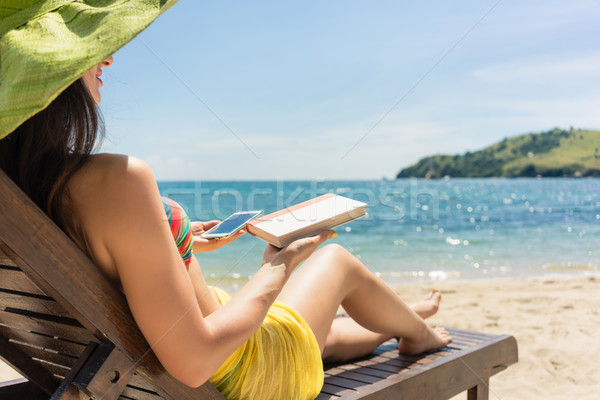 Young woman undecided between reading a book and spending time o Stock photo © Kzenon