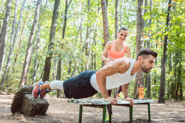Sporty man doing push-up in an outdoor gym Stock photo © Kzenon