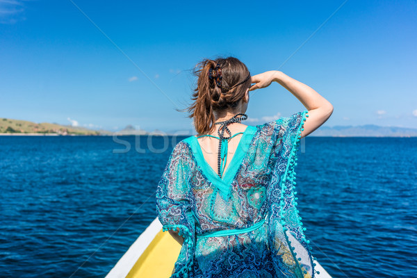 Young woman looking away to the horizon while sitting on a jetty at seashore Stock photo © Kzenon