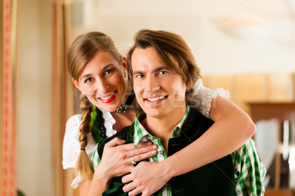Young couple in traditional Bavarian Tracht in restaurant or pub Stock photo © Kzenon