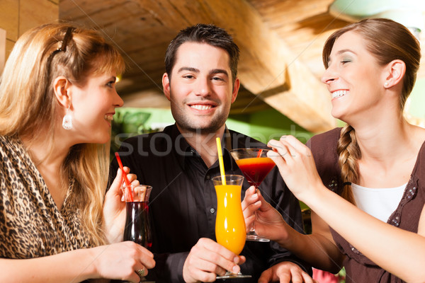 Young people drinking cocktails in bar or restaurant Stock photo © Kzenon