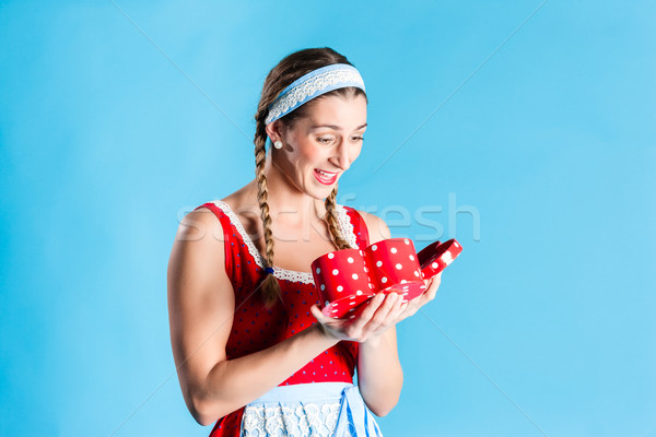 Woman in dirndl dress opening gift or present Stock photo © Kzenon