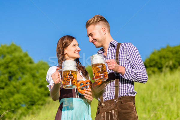 German couple in Tracht with beer and pretzel Stock photo © Kzenon