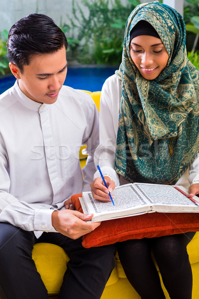 Asian Muslim couple reading together Koran or Quran  Stock photo © Kzenon