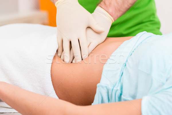 Practitioner at colon therapy massaging abdomen Stock photo © Kzenon