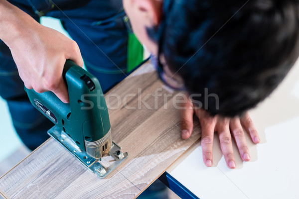 DIY worker cutting wooden panel with jig saw Stock photo © Kzenon