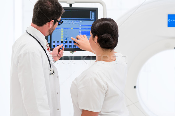 Doctor and nurse analyzing data of CT scan Stock photo © Kzenon