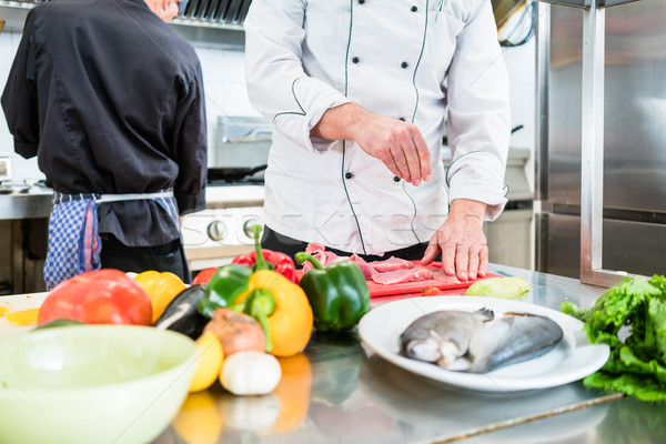 Chef putting salt on fish while cooking in kitchen Stock photo © Kzenon