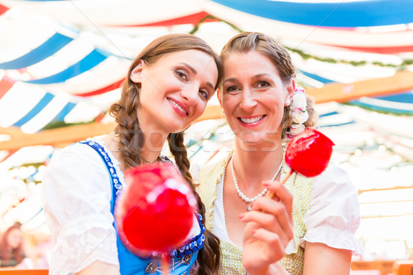 Friends in a beer tent holding candy apples Stock photo © Kzenon