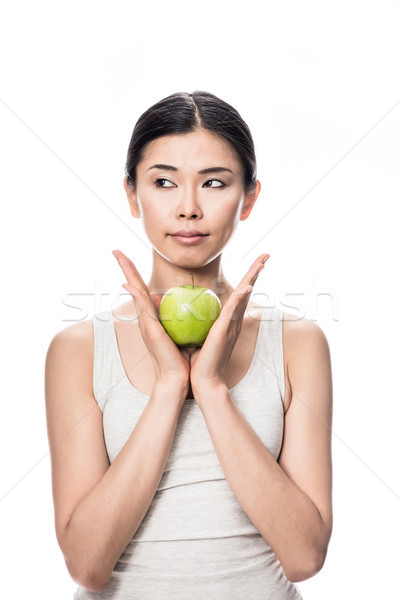 Thoughtful young Asian woman holding a green apple Stock photo © Kzenon