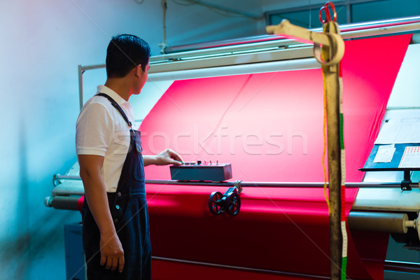 Asian worker controls fabrics in textile plant Stock photo © Kzenon