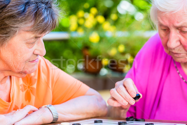 Stock photo: Two senior ladies playing board game in rest home